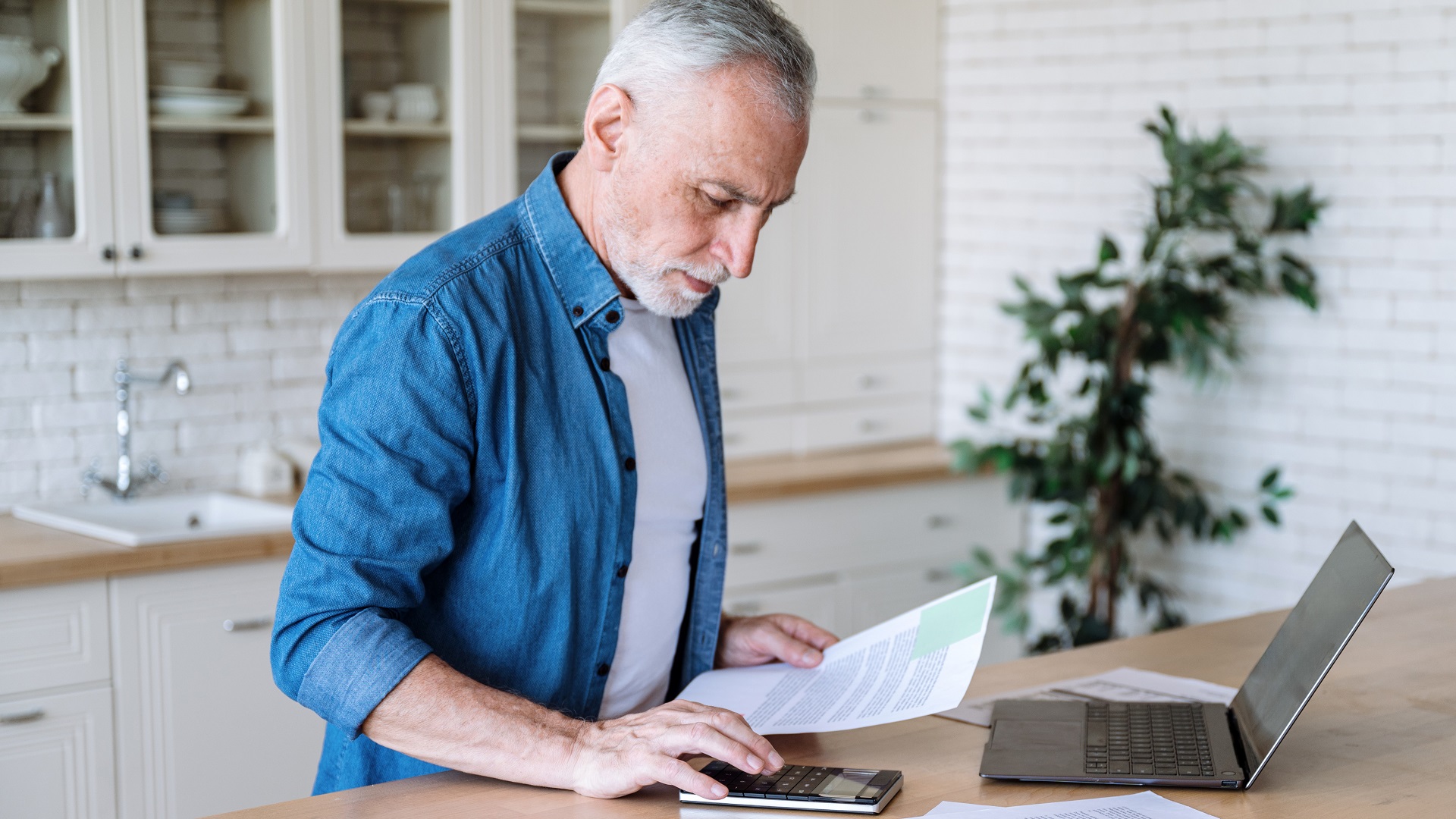 Focused middle aged man making calculations of utility payment stock photo