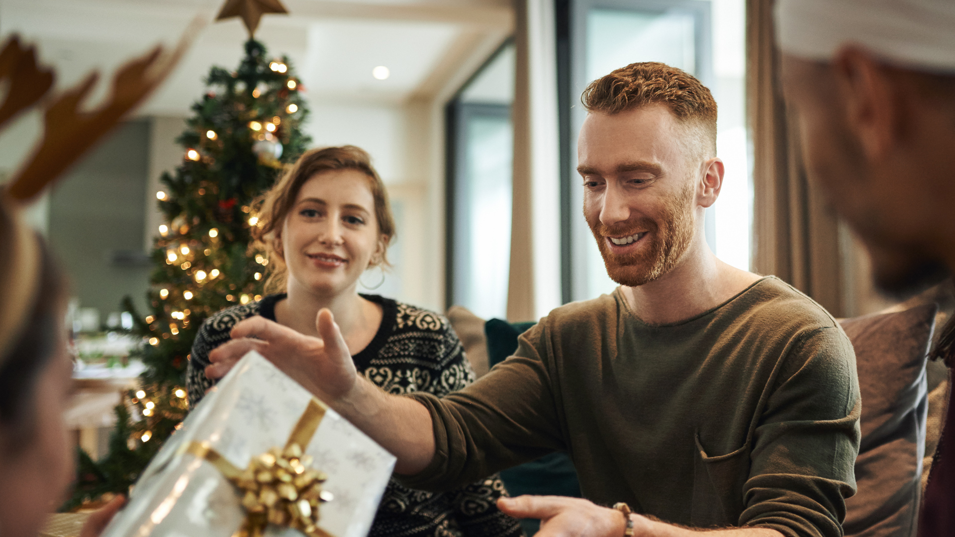 Shot of young friends opening their Christmas gifts together at home.