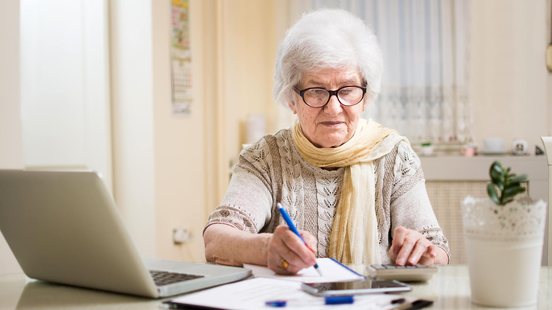 Senior businesswoman calculating taxes at home.